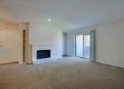 Thumbnail 53 of 57 - an empty living room with a fireplace and a sliding glass door at Indian Creek Apartments, Carrollton, TX, 75007