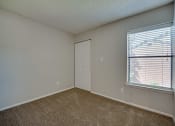 Thumbnail 14 of 57 - an empty bedroom with a large window and a door at Indian Creek Apartments, Texas
