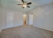 Thumbnail 56 of 57 - an empty living room with a ceiling fan and walls at Indian Creek Apartments, Carrollton, Texas