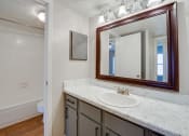 Thumbnail 57 of 57 - a bathroom with a sink and a mirror and a toilet at Indian Creek Apartments, Carrollton