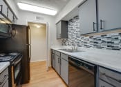 Thumbnail 50 of 57 - an empty kitchen with a sink and a refrigerator at Indian Creek Apartments, Carrollton, Texas