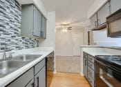 Thumbnail 49 of 57 - a kitchen with white counter tops and stainless steel appliances at Indian Creek Apartments, Carrollton, 75007