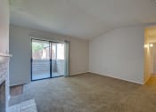 Thumbnail 48 of 57 - an empty living room with a fireplace and a sliding glass door at Indian Creek Apartments, Carrollton, TX