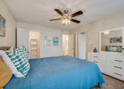 Thumbnail 7 of 57 - a bedroom with a bed and a ceiling fan at Indian Creek Apartments, Carrollton, 75007