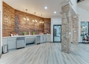 Thumbnail 52 of 68 - A kitchen with a stone wall and wooden floors at Limestone Ranch Apartments, Lewisville, TX, 75067