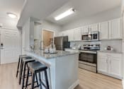 Thumbnail 2 of 68 - A kitchen with a bar area and stools at Limestone Ranch Apartments, Lewisville, TX, 75067