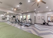 Thumbnail 38 of 68 - A spacious gym with a variety of equipment including treadmills, stationary bikes, and weight machines at Limestone Ranch Apartments, Lewisville