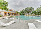 Thumbnail 24 of 68 - A pool with a white slide and a house in the background at Limestone Ranch Apartments, Lewisville, TX