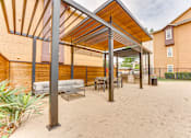 Thumbnail 31 of 68 - A patio with a white couch and a table under a roof at Limestone Ranch Apartments, Lewisville 75067