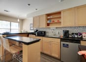 Thumbnail 25 of 32 - a kitchen with wooden cabinets at The Manhattan Apartments, Dallas, 75252