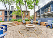 Thumbnail 26 of 51 - A courtyard with a fire pit surrounded by chairs and trees. at The Manhattan Apartments, Dallas, TX