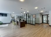 Thumbnail 43 of 51 - A modern office space with a wooden floor and a green chair. at The Manhattan Apartments, Dallas, Texas
