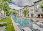 Thumbnail 40 of 52 - Outdoor swimming pool with sundeck and lounge chairs at The Montrose Apartments, Dallas