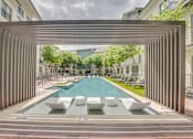 Thumbnail 36 of 52 - Pool with pergola and modern loungers at The Montrose Apartments, Dallas, TX