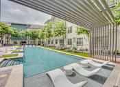 Thumbnail 32 of 52 - Pool area with tanning ledge and modern pergola at The Montrose Apartments, Dallas, 75204