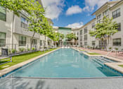 Thumbnail 41 of 52 - Courtyard pool with sun shelf and seating areas at The Montrose Apartments, Texas