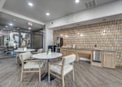 Thumbnail 29 of 52 - Community kitchen with tile accent wall and seating at The Montrose Apartments, Dallas, Texas