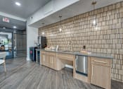 Thumbnail 31 of 52 - Community kitchen with wood cabinetry and pendant lighting at The Montrose Apartments, Texas