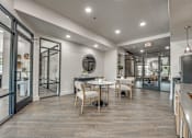 Thumbnail 26 of 52 - Resident lounge with round tables and glass partitions at The Montrose Apartments, Dallas, TX