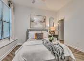Thumbnail 9 of 52 - Bedroom with upholstered bed and abstract artwork at The Montrose Apartments, Dallas, TX 75204