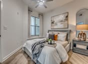 Thumbnail 8 of 52 - Bedroom with upholstered bed and arched mirror at The Montrose Apartments, Dallas, 75204