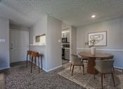 Thumbnail 3 of 41 - A dining room with a table and chairs.