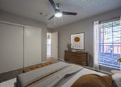 Thumbnail 7 of 41 - A bedroom with a bed, dresser, and sliding door.