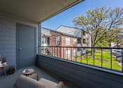 Thumbnail 14 of 41 - A balcony with a grey floor and a blue door.
