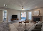 Thumbnail 2 of 41 - A living room with a fireplace and a television.