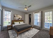 Thumbnail 5 of 41 - A bedroom with a bed, dresser, and sliding glass doors.