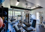 Thumbnail 31 of 41 - a gym with weights and other exercise equipment in a building with windows at Paces Crossing, Denton