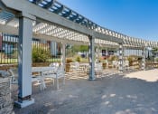 Thumbnail 22 of 41 - a covered patio with tables and chairs next to a pool at Paces Crossing, Denton