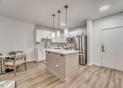 Thumbnail 2 of 53 - Open concept kitchen with island and pendant lighting at The Barton Apartments, Dallas