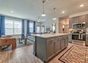 Thumbnail 1 of 29 - A modern kitchen with a large island and a dining area.