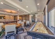 Thumbnail 23 of 29 - A room with a shaggy carpet and a long table with chairs and a shuffleboard table.
