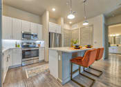 Thumbnail 9 of 29 - A kitchen with a table and chairs in the middle of it.