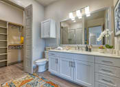 Thumbnail 11 of 29 - A bathroom with a toilet, sink, and a mirror.