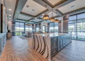 Thumbnail 25 of 29 - A modern kitchen with a large island and pendant lights.