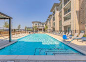 Thumbnail 12 of 29 - A swimming pool in front of apartment buildings.