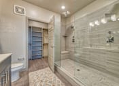 Thumbnail 7 of 29 - A bathroom with a walk-in shower and a toilet.