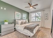 Thumbnail 8 of 37 - Bedroom with sage accent wall and ceiling fan at Vue Live Oak Apartments, Texas