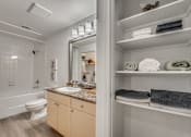 Thumbnail 12 of 37 - Bathroom with linen storage and granite vanity at Vue Live Oak Apartments, Dallas, TX