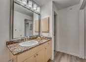 Thumbnail 11 of 37 - Bathroom vanity with granite countertop and mirror at Vue Live Oak Apartments, Dallas, 75204