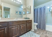 Thumbnail 14 of 39 - A bathroom with a wooden vanity and a white toilet. at Wilson Crossing, Texas