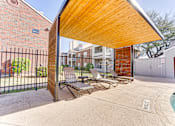Thumbnail 16 of 39 - A wooden covered patio area with a pool and lounge chairs. at Wilson Crossing, Cedar Hill, 75104