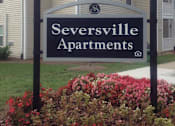 Thumbnail 1 of 7 - A sign for Seversville Apartments is in front of a building.