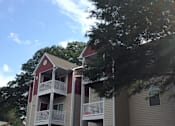 Thumbnail 4 of 7 - Apartment building with a red roof and white balconies.