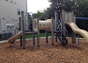 Thumbnail 5 of 7 - A playground with a slide, swings, and a tunnel.