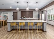 Thumbnail 10 of 19 - A kitchen with a bar area and chairs.