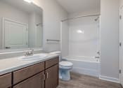 Thumbnail 4 of 19 - A white bathroom with a toilet, sink, and bathtub.